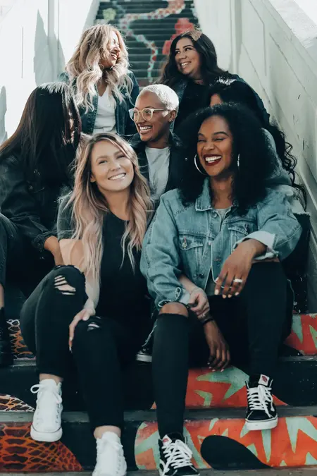 Women Sitting on a flight of stairs smiling at each other